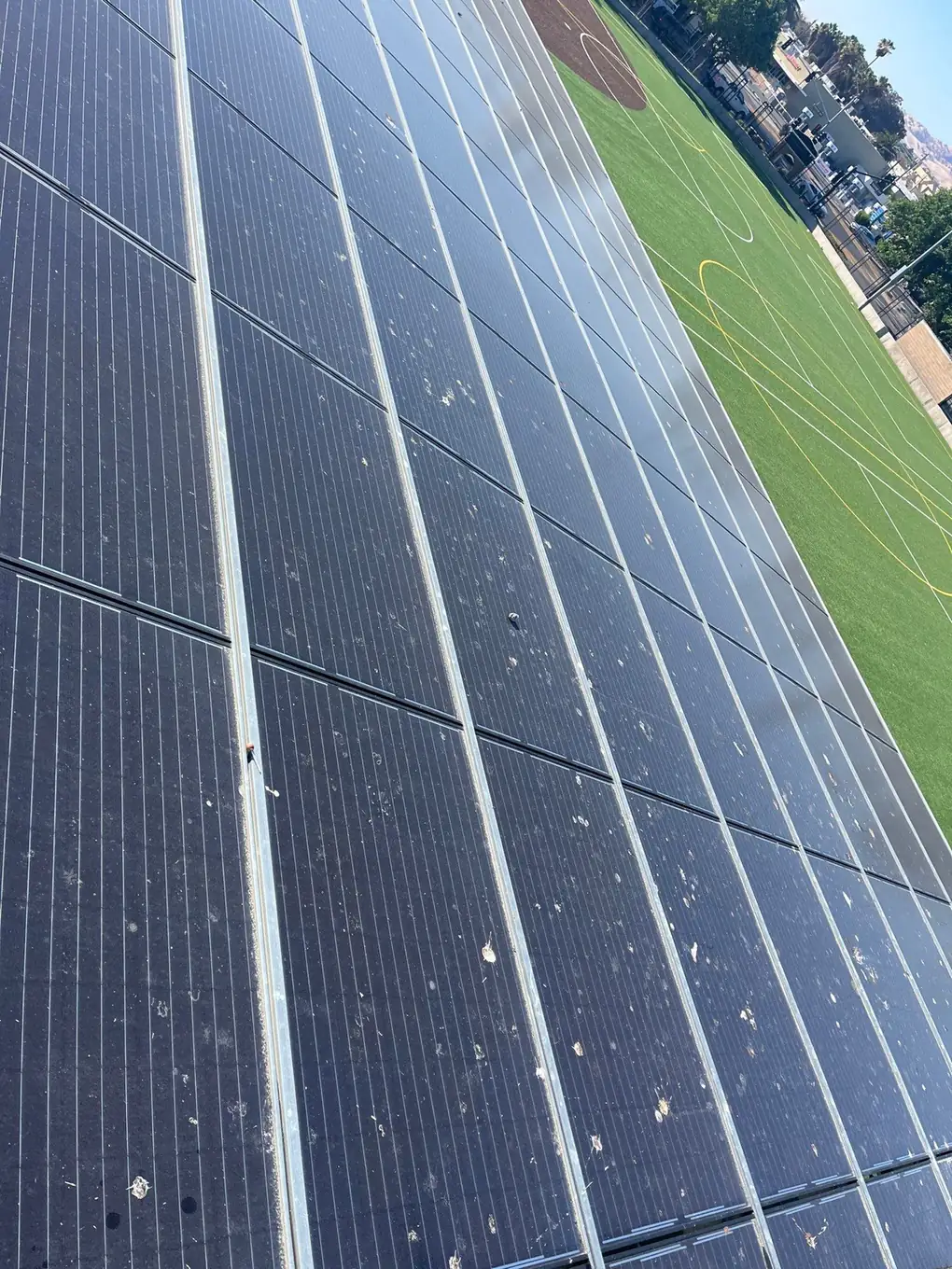 Solar carport panels heavily soiled with dust and bird droppings before cleaning, Pittsburg school district